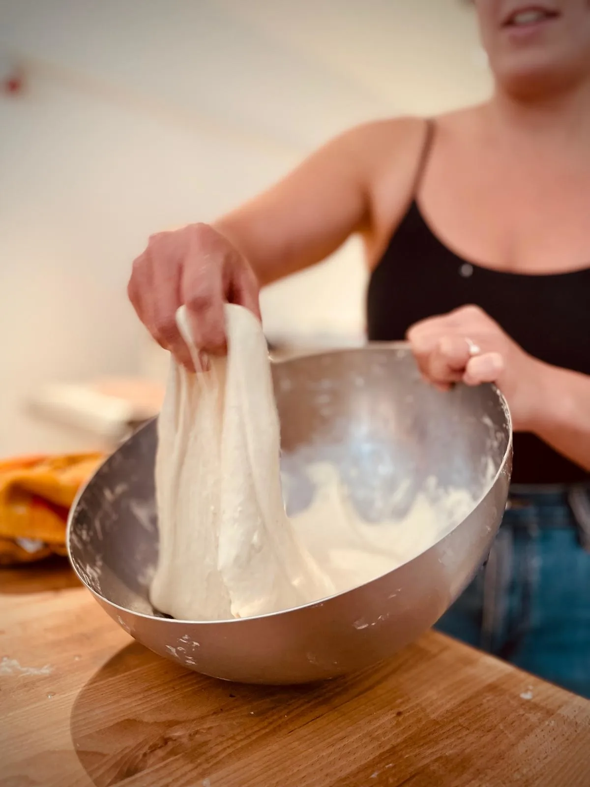 Nona demonstreert hoe je zuurdesembrood maakt tijdens een no-knead zuurdesem workshop in Antwerpen.